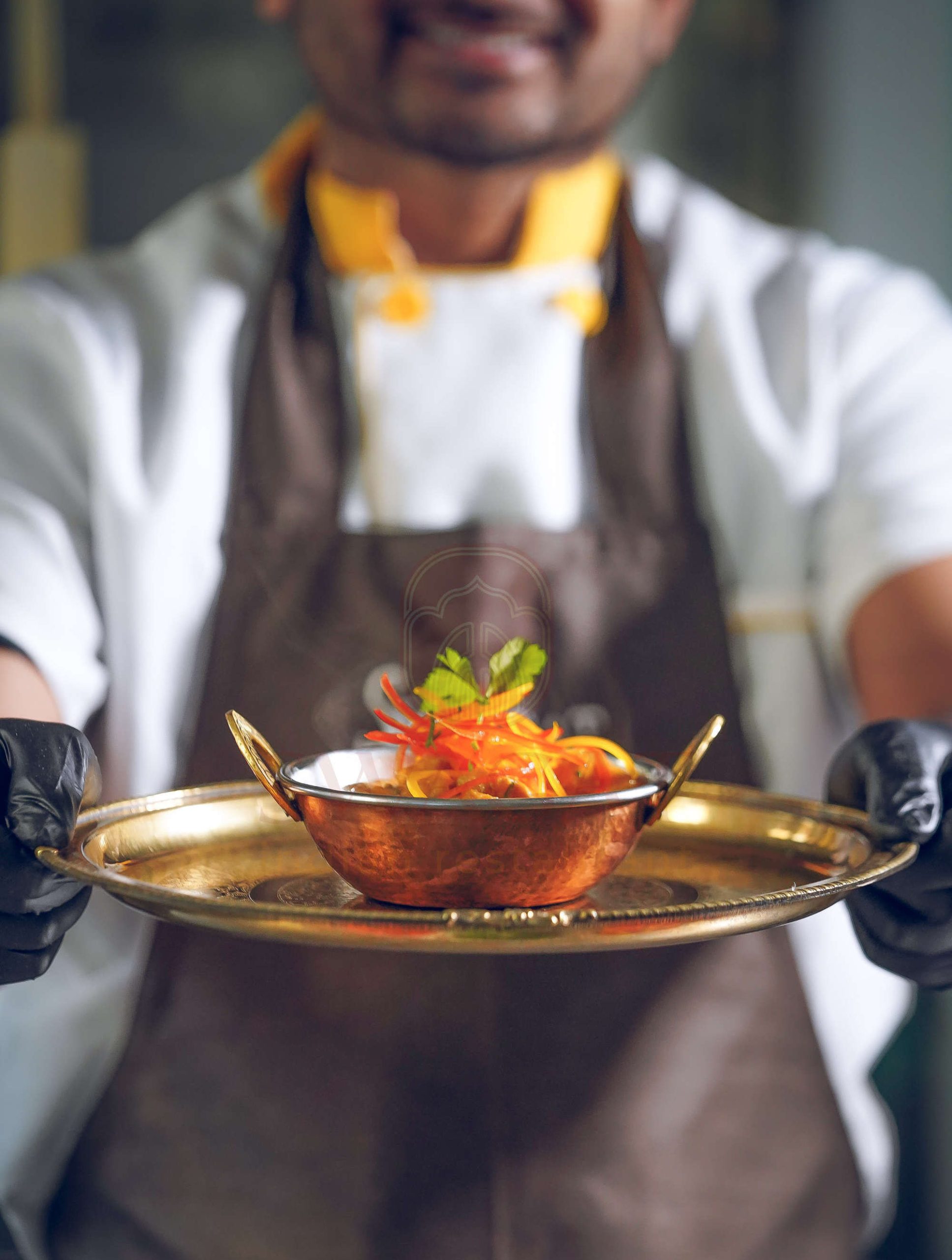 Uno cheff indiano propone un piatto speziato a base di lenticchie.
